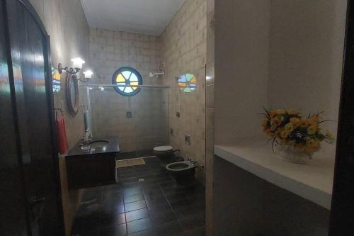 a bathroom with a sink and a toilet and a window at Casa de campo Sede de Fazenda - MT in Nossa Senhora do Livramento