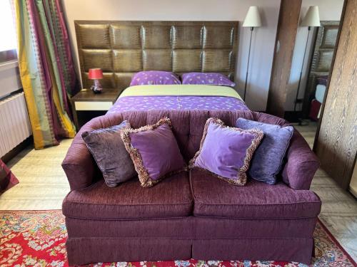 a purple couch with purple pillows in a bedroom at Studio dans le quartier luxe in Neuilly-sur-Seine