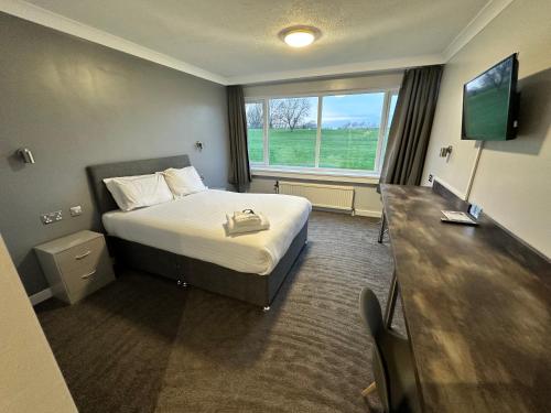 a hotel room with a bed and a window at Sporting Lodge Inn Middlesbrough in Middlesbrough