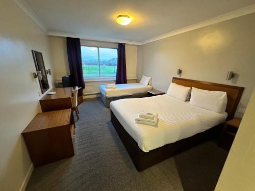 a hotel room with two beds and a window at Sporting Lodge Inn Middlesbrough in Middlesbrough
