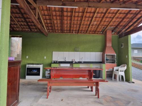 a kitchen with a table and a bench in a room at O Zóio da cobra é verde in Bragança Paulista