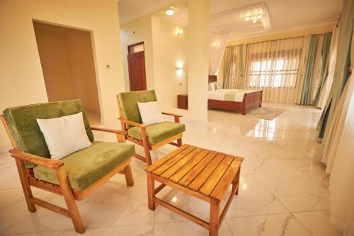 a living room with two chairs and a bed at The Forest House - Kawuku-Bunga in Kampala