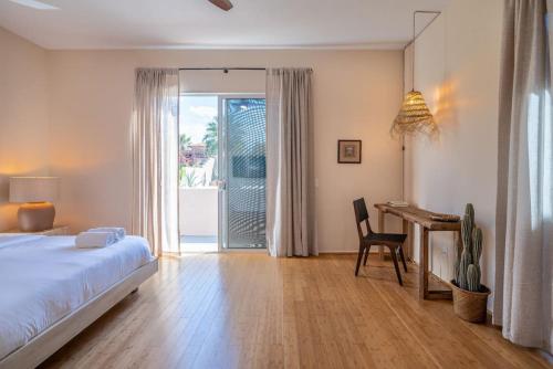 a bedroom with a bed and a desk and a table at Pueblo Viejo Desert Minimalist Pool Home in Bermuda Dunes