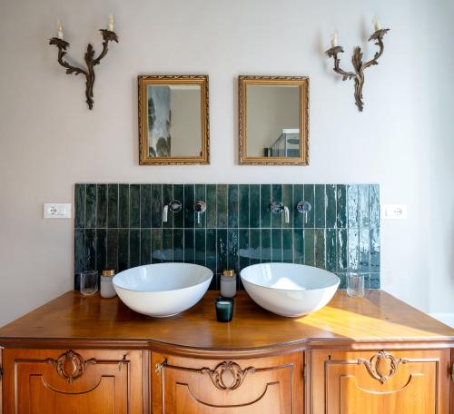 two sinks on a wooden counter with two mirrors at Ziolì in Noto