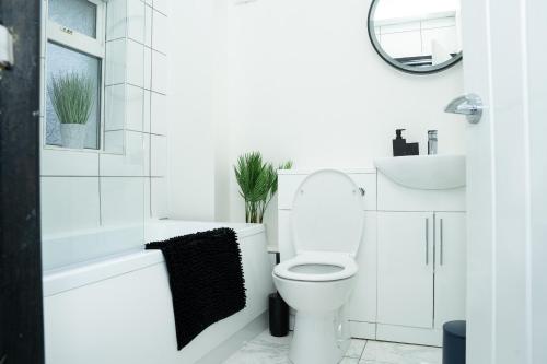 a white bathroom with a toilet and a sink at A modern home close to city centre with parking in Killingbeck