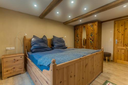a bedroom with a large wooden bed with blue pillows at Spreewald Fewo direkt am Wasser in Lübbenau