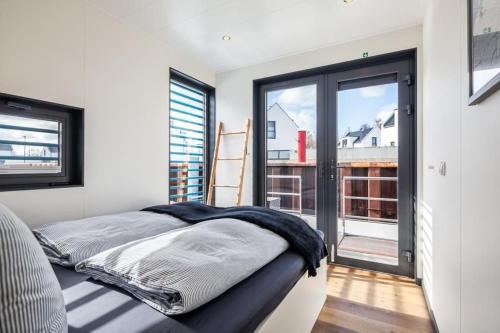 a bedroom with a bed and a large window at Hausboot Chalet am Meer - LP8 in Peenemünde