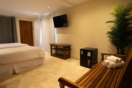 a bedroom with a bed and a tv on the wall at Pousada La Dolce Vita in Búzios