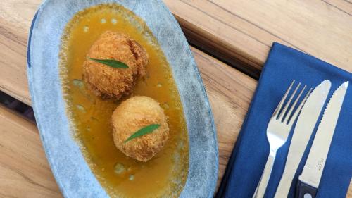 a plate of food with two fried food in a yellow sauce at La Bambouseraie in Balgue