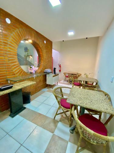 una stanza con tavoli, sedie e uno specchio di Felicità Praia Hotel a Fortaleza