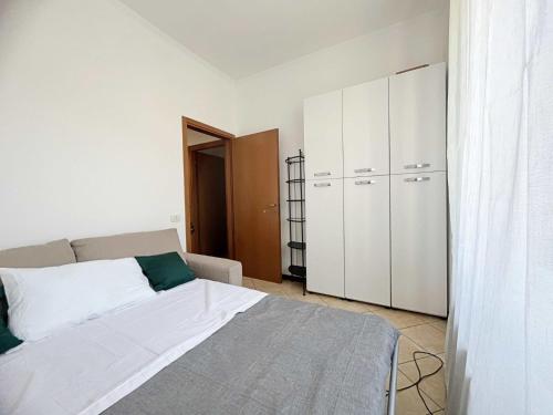 biała sypialnia z łóżkiem i szafą w obiekcie Appartamento confortevole con terrazza w Como