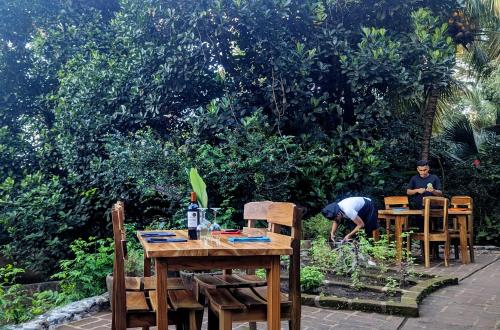 a man sitting at a table in a garden at La Bambouseraie in Balgue