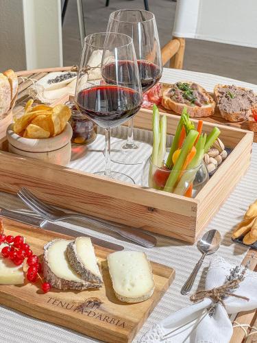 a table with a tray of cheese and a glass of wine at Tenuta d'Arbia, Siena in Monteroni dʼArbia