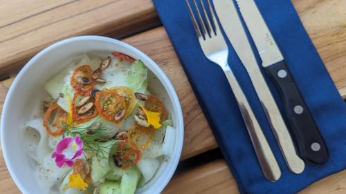 a bowl of food on a table with a fork and knife at La Bambouseraie in Balgue