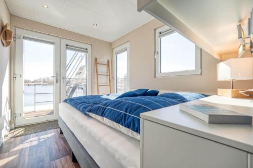 a bedroom with a bed and a sink and windows at Hausboot Mein Lieblingsboot in Ribnitz-Damgarten