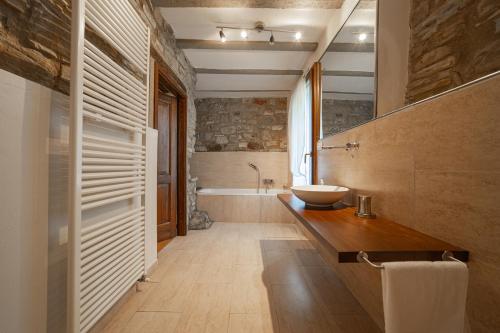 a bathroom with a sink and a bath tub at Borgo Pianello Country Resort in Lizzano in Belvedere