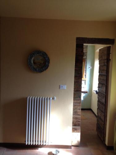 a hallway with a plate on the wall and a radiator at R&B Mulino Marsa in CastellʼArquato