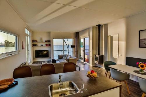 een keuken en een woonkamer met een wastafel en een tafel bij Hausboot Boddenperle in Ribnitz-Damgarten