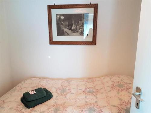 ein Bett mit einer grünen Tüte darüber. in der Unterkunft "Pipistrello" 3 Zimmer grosses bezauberndes freistehendes Tessiner Ferienhaus mit unglaublich viel Charme in Ronco sopra Ascona