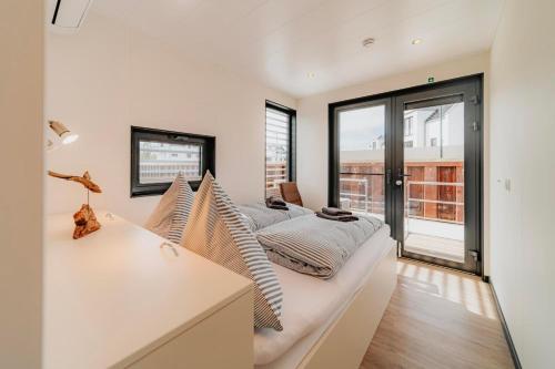 a bedroom with a bed and a large window at Hausboot Trinity - LP5 in Peenemünde