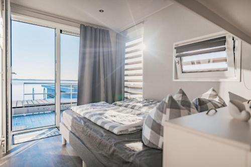 ein Hotelzimmer mit einem Bett und einem Balkon in der Unterkunft Hausboot Möwe 2 - LP2 in Laasow