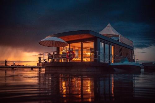 ein Haus auf einem Boot im Wasser in der Unterkunft Hausboot Möwe 2 - LP2 in Laasow