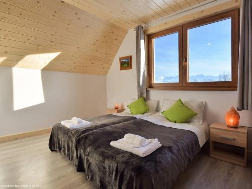 a bedroom with a large bed with two green pillows at Domki Trzy Tatry in Ząb