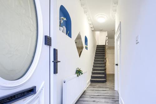 a hallway with a white door and stairs at Hackney Central Deluxe Apartment in London