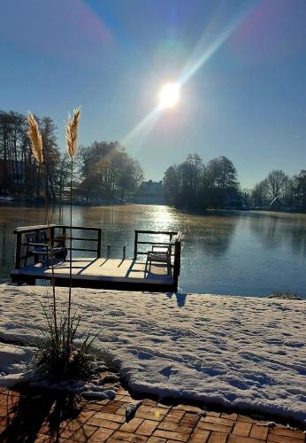 two benches sitting on a dock in the middle of a lake at Landhaus Lotten in Winsen Luhe