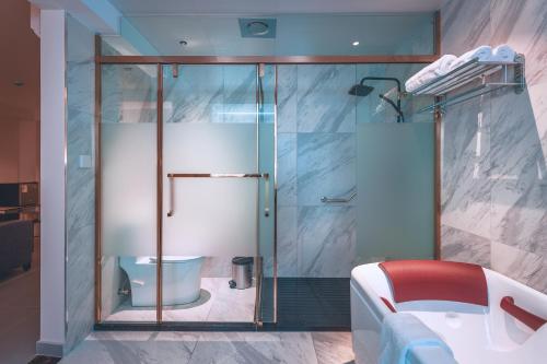 y baño con ducha de cristal y aseo. en Lyz Business Hotel Piura, en Piura