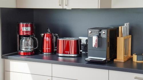 a kitchen counter with red appliances on a counter top at Hausboot Möwenschiss - LP3 in Höxter