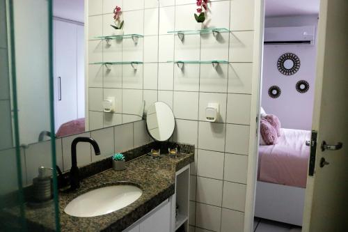 um banheiro com pia e espelho em Apartamento com Varanda vista mar, Max 4 Pessoas em Fortaleza