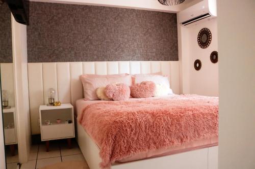 Una cama rosa con dos ositos de peluche. en Apartamento com Varanda vista mar, Max 4 Pessoas, en Fortaleza