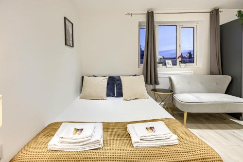 a bedroom with a large bed and a chair at The Finsbury Deluxe Apartments in London