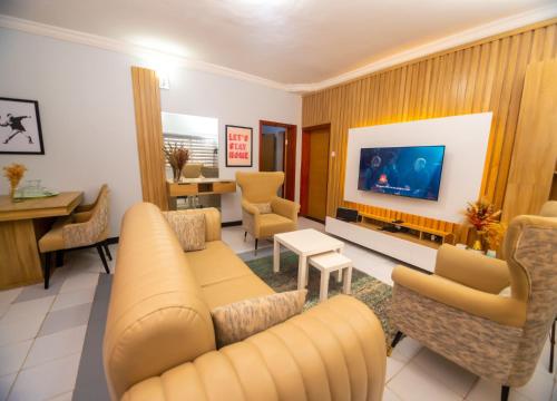 a living room with a couch and chairs and a tv at Palm Heights Apartments - Omole Phase 1, Ikeja in Ikeja