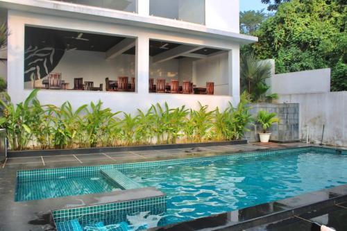 uma casa com piscina em frente a uma casa em Premium 2BHK Apartment with pool at Candolim Beach em Candolim