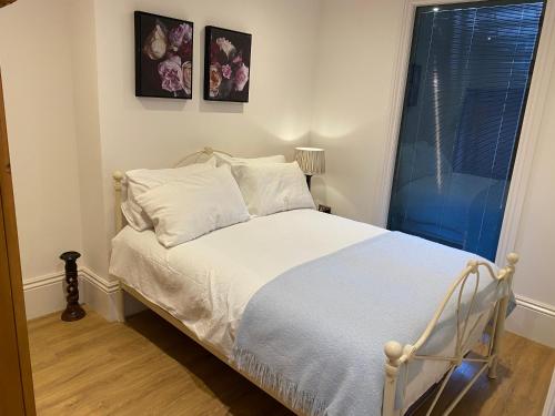 a bedroom with a bed with white sheets and a window at No 10, St James Street, Burnley in Burnley