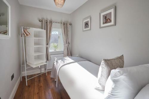una camera bianca con un letto e una finestra di Host & Stay - Snoozy Goose a Ovingham