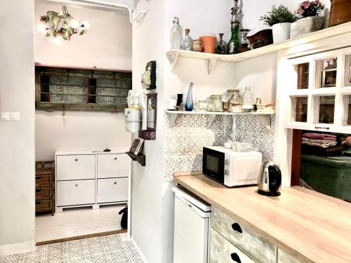 La cuisine est équipée de placards blancs et d'un four micro-ondes. dans l'établissement Szentkirályi Art Studio, à Budapest