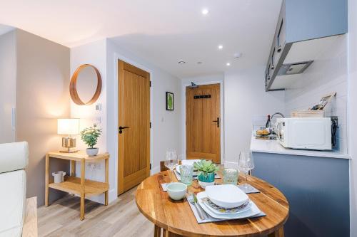 a kitchen and dining room with a wooden table at Rock Mill - Deluxe Studio Apartments in Stoney Middleton