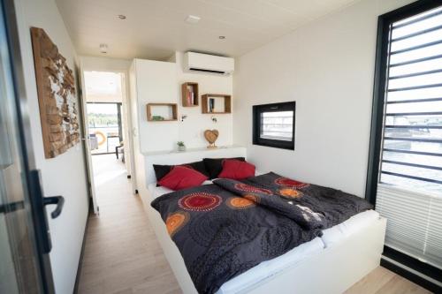 um quarto numa pequena casa com uma cama em Hausboot the Hideaway LP25 em Klitten