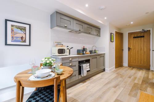 a kitchen with a wooden table and a wooden floor at Rock Mill - Deluxe Studio Apartments in Stoney Middleton