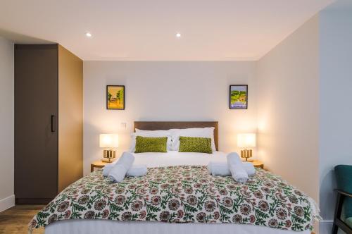a bedroom with a large bed with two lamps at Rock Mill - Deluxe Studio Apartments in Stoney Middleton