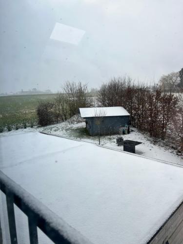 a snow covered roof with a building in the background at L'échappée Belle by J&J Durbuy Area in Clavier