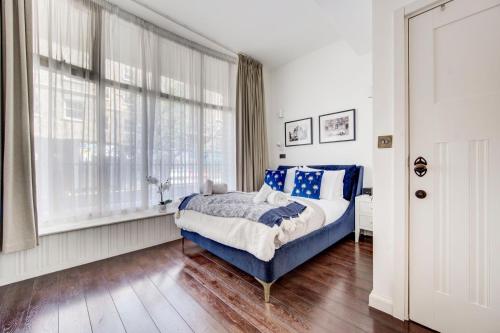 a bedroom with a blue bed and a window at 4 guests | Smart TV | Attractions in London