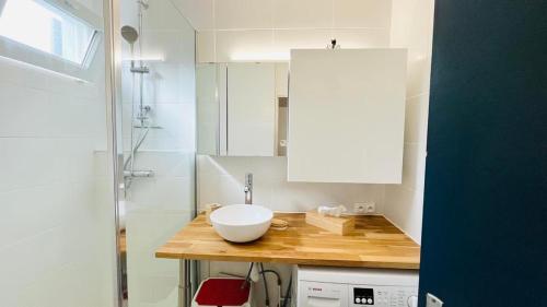 a bathroom with a white sink on a wooden counter at Appartement Solane 2 LUMIO in Lumio