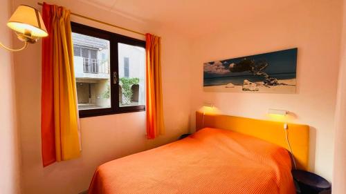 a bedroom with an orange bed and a window at Appartement Solane 2 LUMIO in Lumio