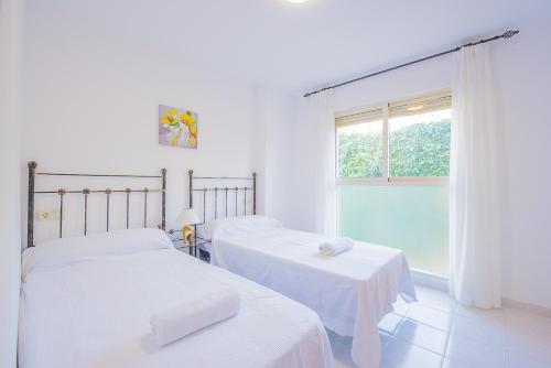2 camas en una habitación blanca con ventana en Apartamento Zeus - PlusHolidays, en Calpe