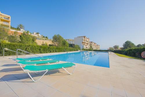 basen z dwoma leżakami obok niego w obiekcie Apartamento Zeus - PlusHolidays w mieście Calpe