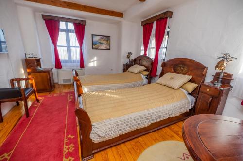 a bedroom with two beds and a table at Etno selo Stanišići Hotel Pirg in Dvorovi